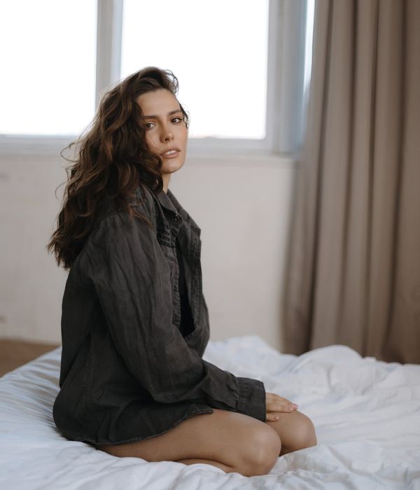 Calm person sitting in a minimalist room with soft light.